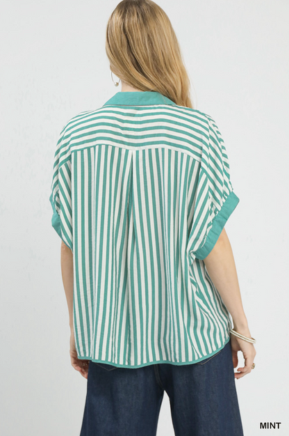 Woman wearing a green and white striped shirt on a plain background