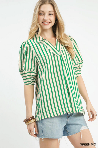 Woman wearing a green and white striped shirt with denim shorts on a white background