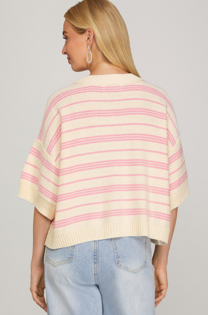 Woman wearing a striped sweater and jeans on a plain background