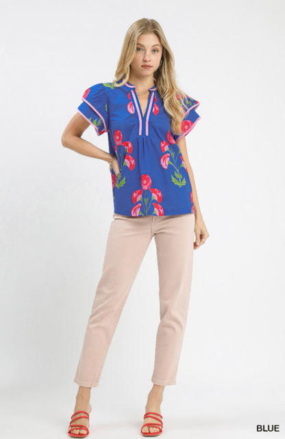 Woman wearing a blue floral blouse and beige pants on a white background