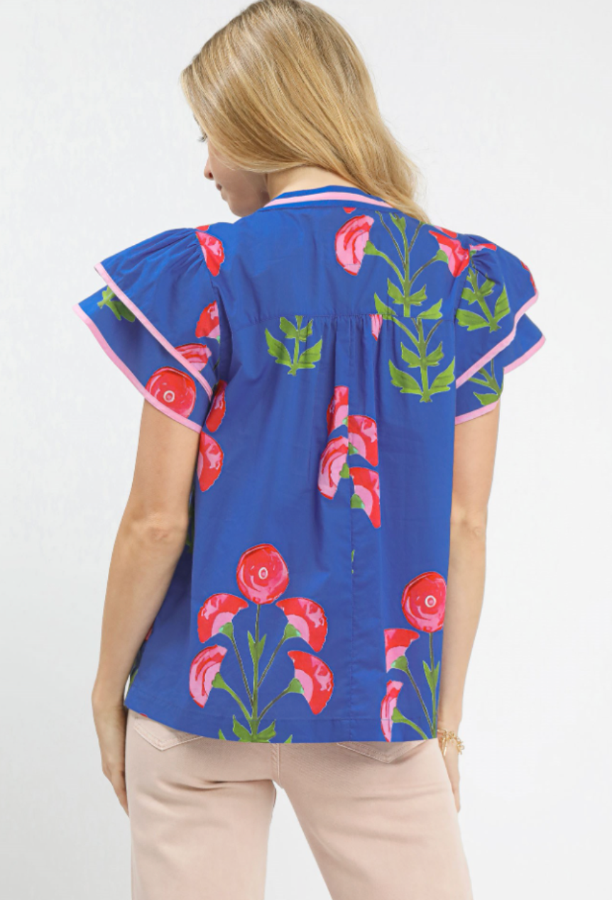 Woman wearing a blue blouse with floral patterns on a white background