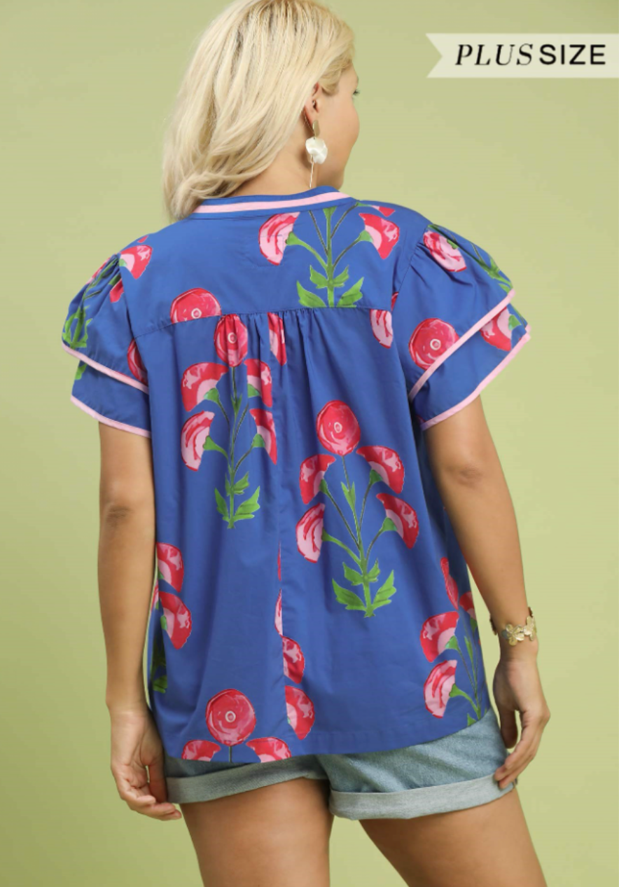 Woman wearing a blue floral blouse with a green background