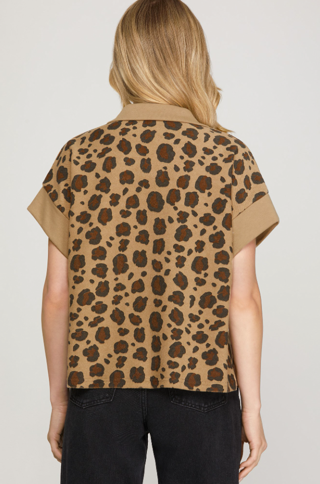 Person wearing a leopard print shirt with a plain background