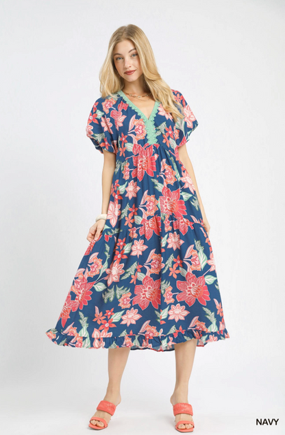 Woman wearing a navy floral dress on a white background