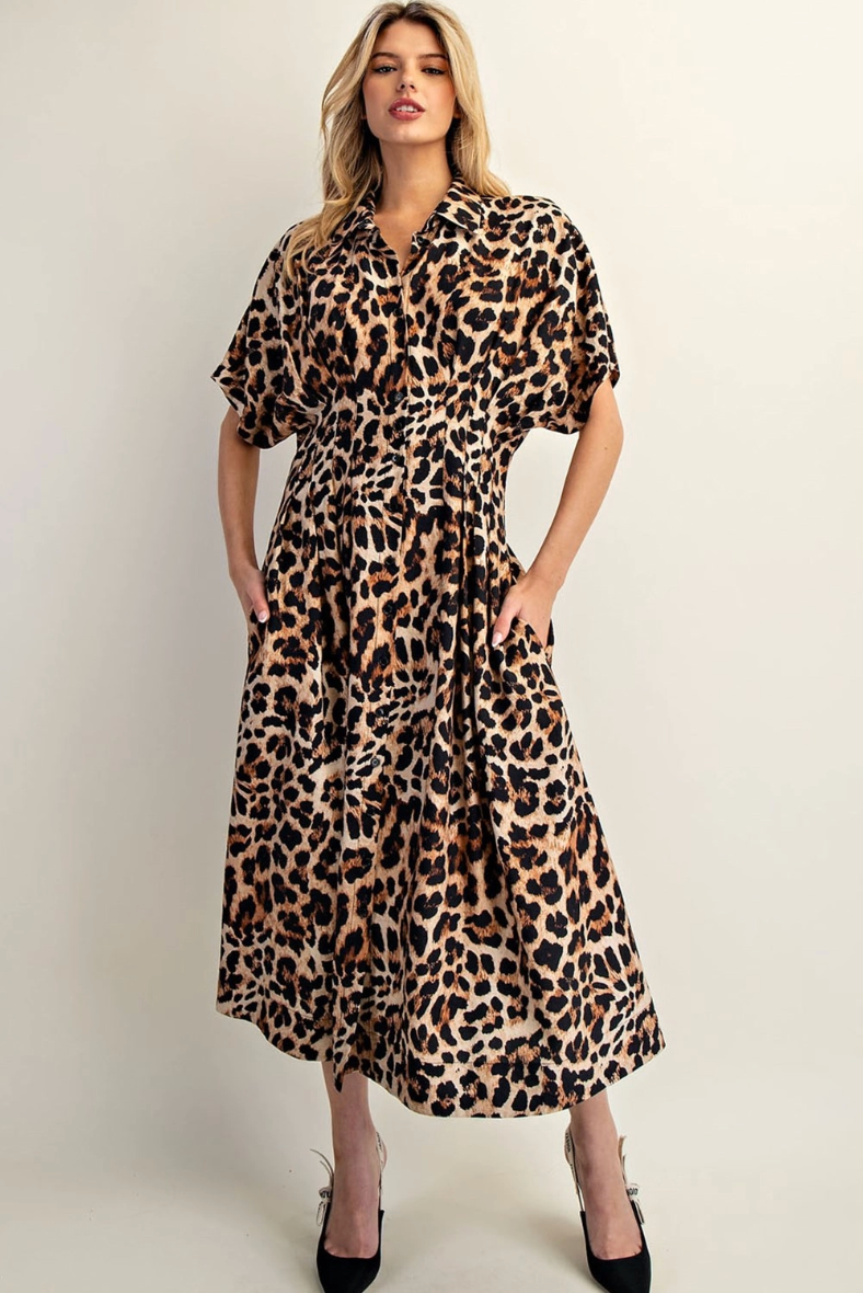 Woman wearing a leopard print dress against a plain background