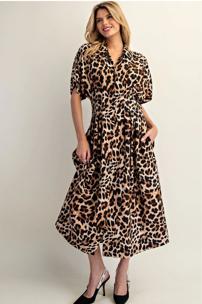 Woman wearing a leopard print dress against a plain background