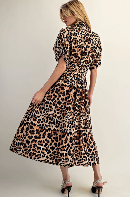 Woman wearing a leopard print dress against a plain background