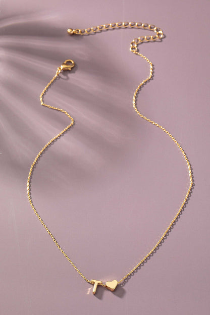 Gold necklace with a heart pendant on a soft purple background