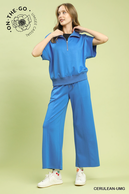 Woman wearing a blue tracksuit with 'On-The-Go' branding on a light green background