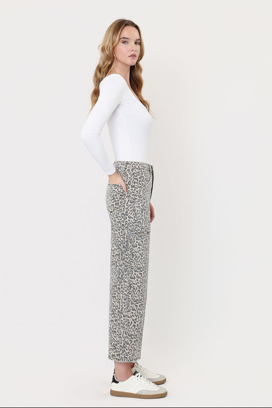 Woman wearing a white long-sleeve top and patterned pants on a white background