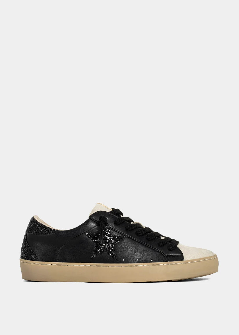 Black sneaker with beige sole on a white background