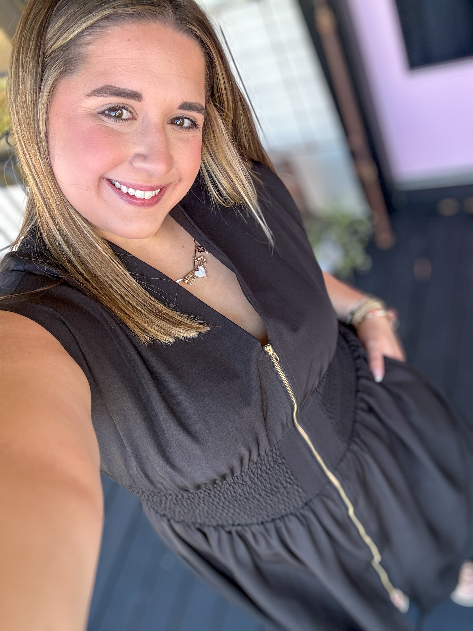 Woman wearing a black sleeveless top with a blurred background