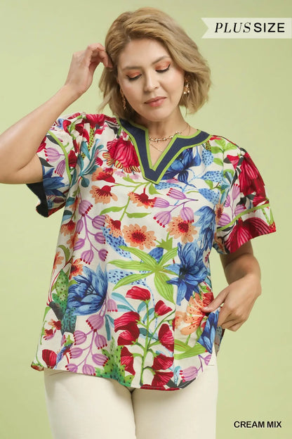 Woman wearing a colorful floral blouse against a light green background