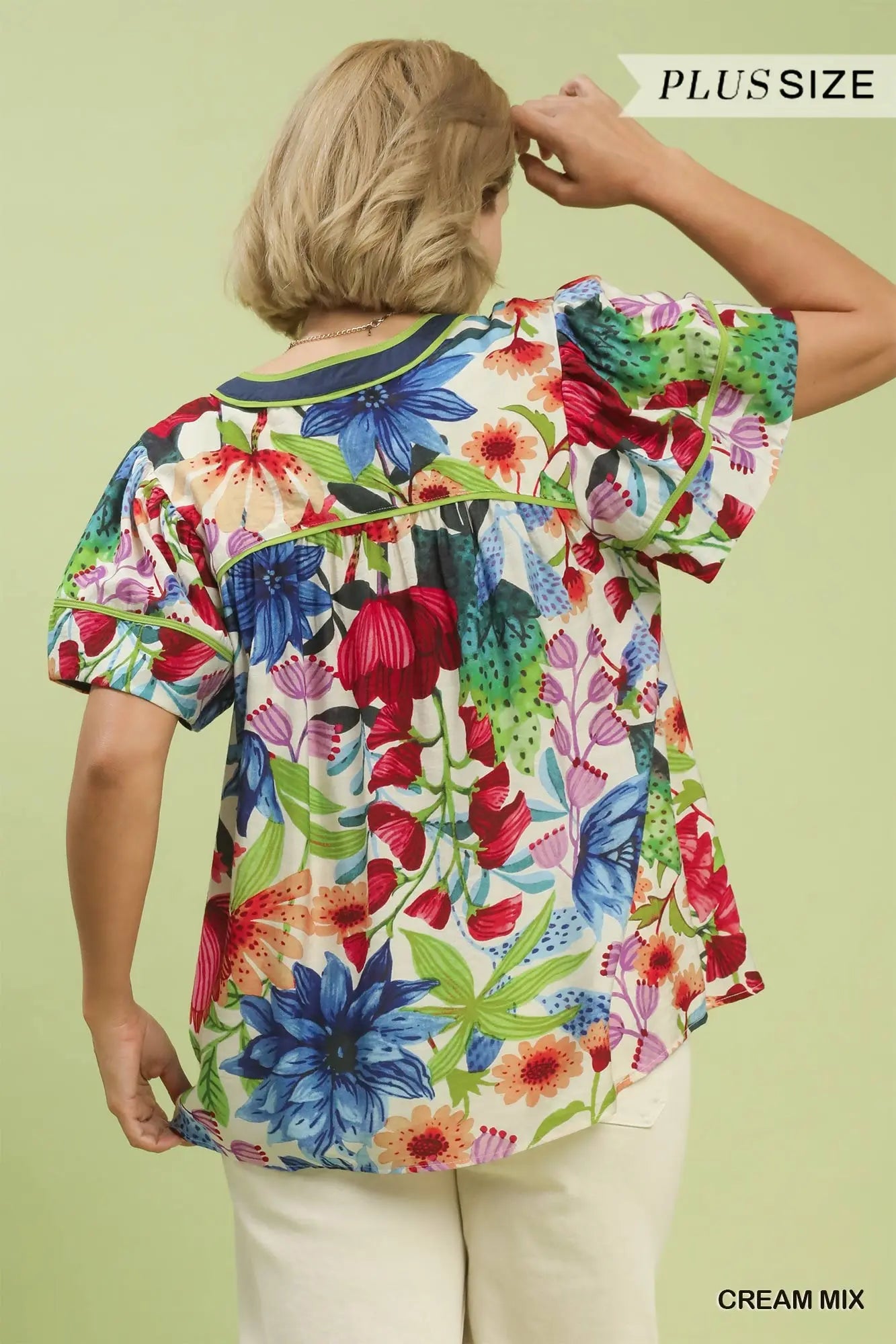 Woman wearing a colorful floral blouse on a light green background