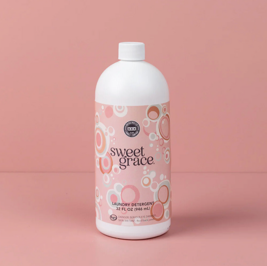 Bottle of Sweet Grace laundry detergent on a pink background