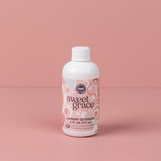 Bottle of Sweet Grace laundry detergent on a pink background