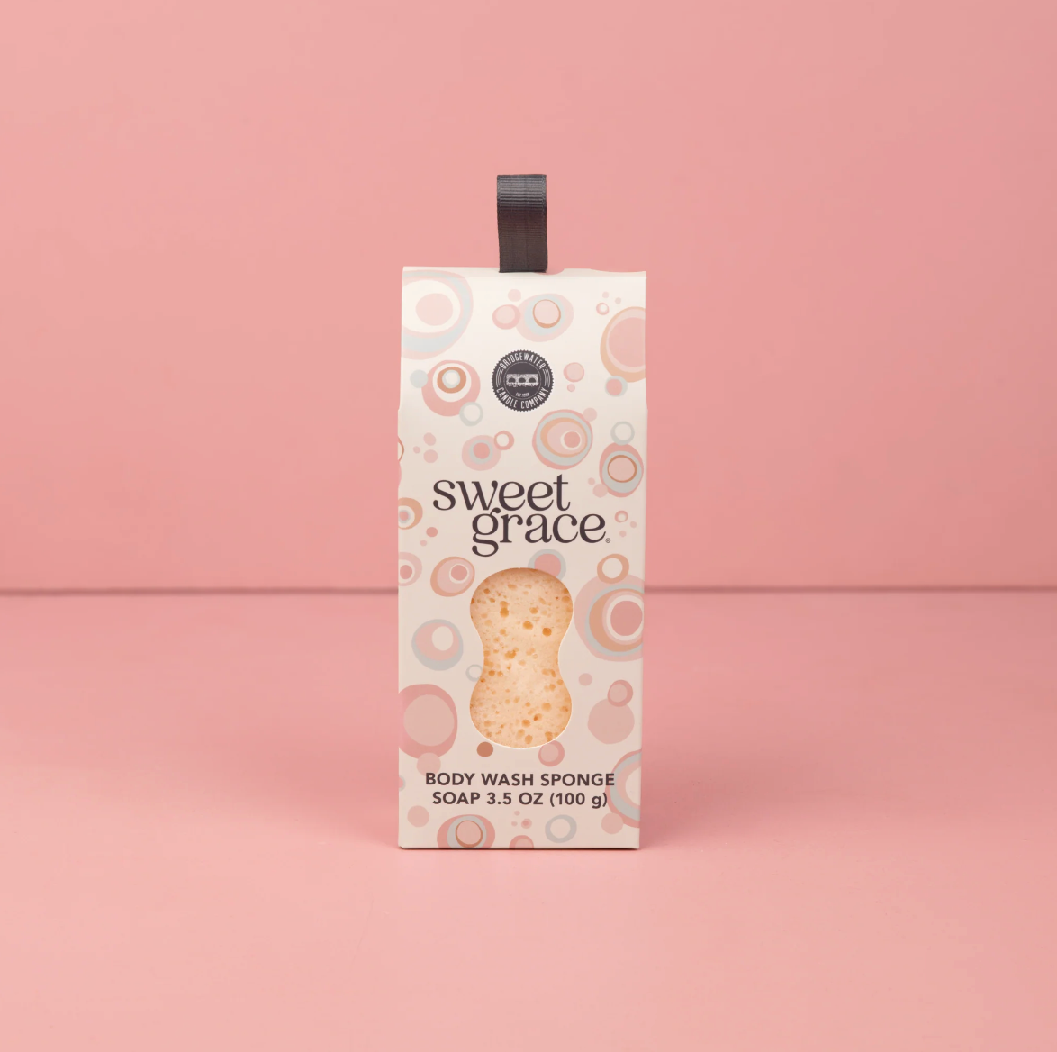 Box of Sweet Grace body wash sponge on a pink background