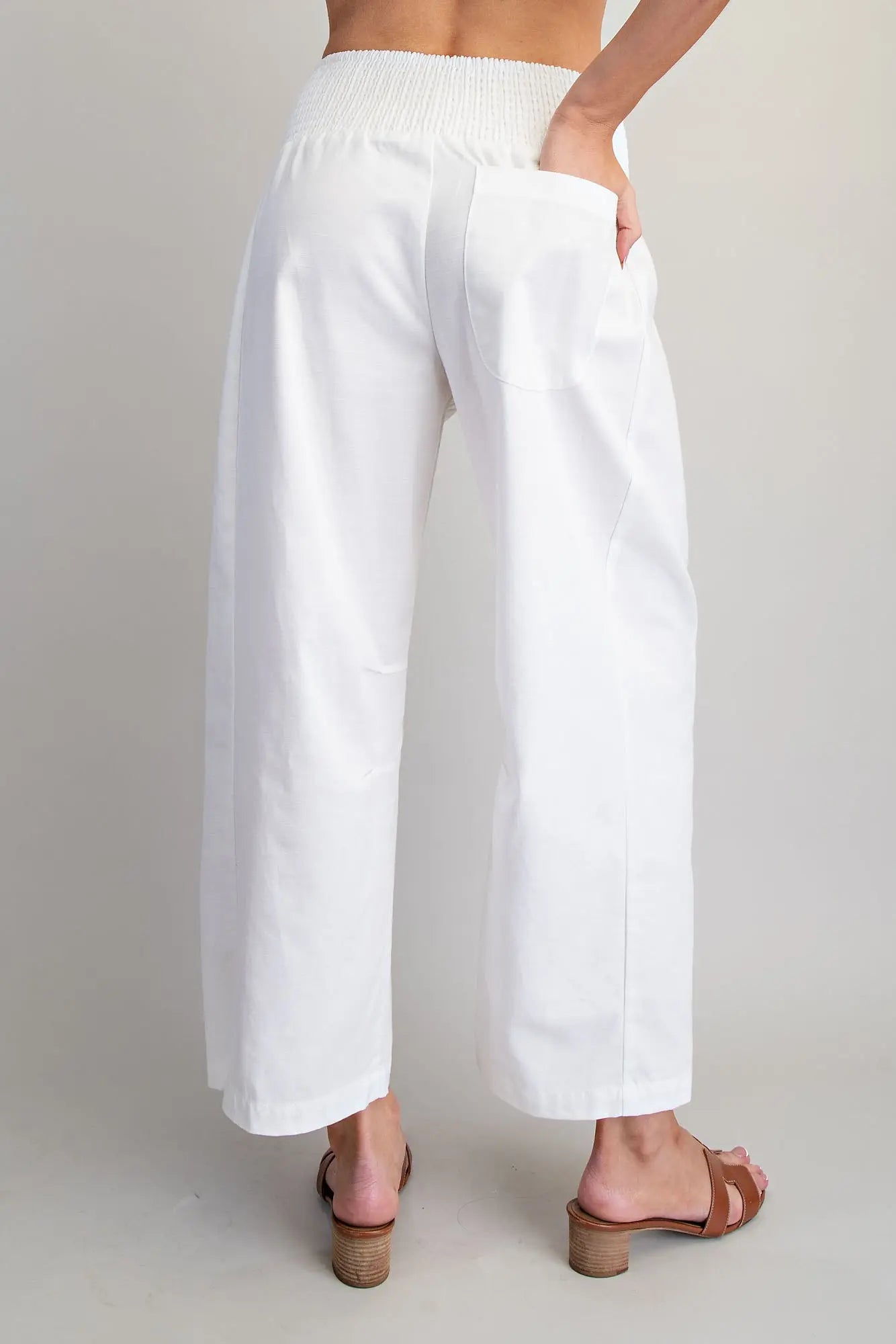 White pants worn by a person on a plain background