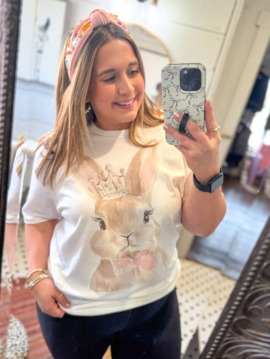 Woman taking a mirror selfie wearing a white sweatshirt with a bunny design.