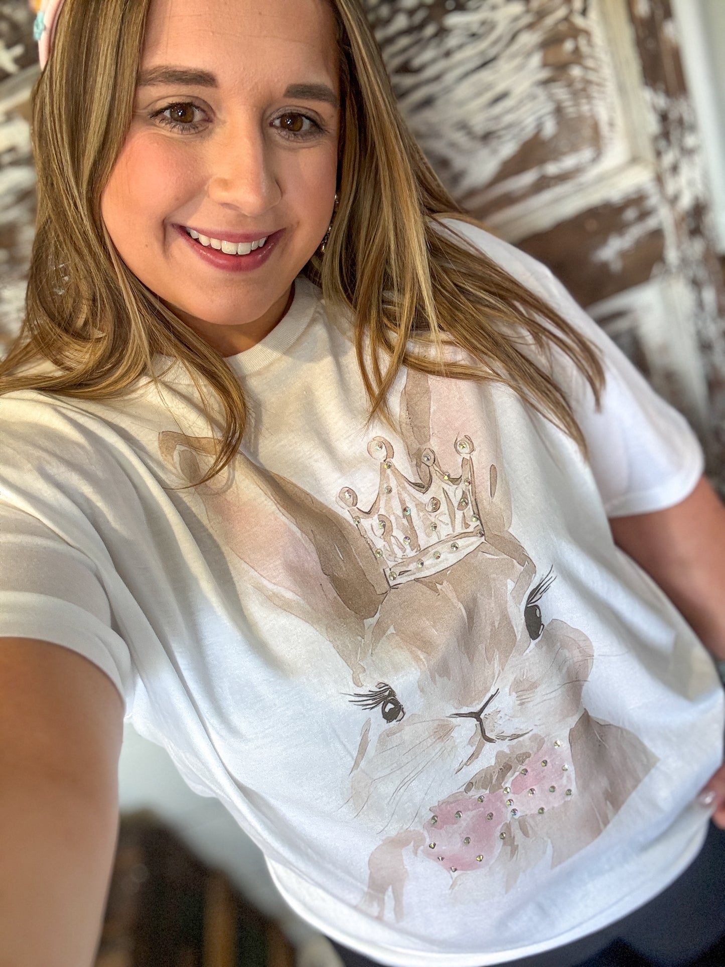 Person wearing a white t-shirt with a graphic design of a cat and crown.