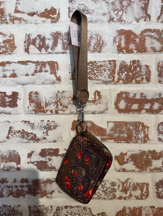 Brown textured pouch with strap on a textured white and brown wall