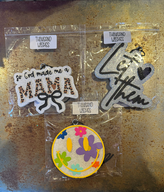 Three decorative patches in clear packaging on a rusty surface