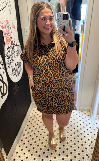 Woman taking a mirror selfie wearing a leopard print dress.