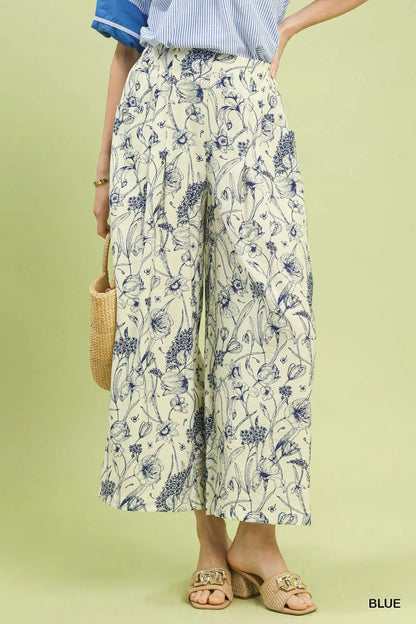 Person wearing floral pants on a light green background
