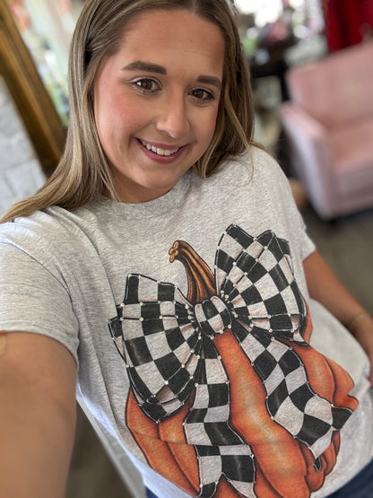 Woman wearing a t-shirt with checkered bow pumpkins design.