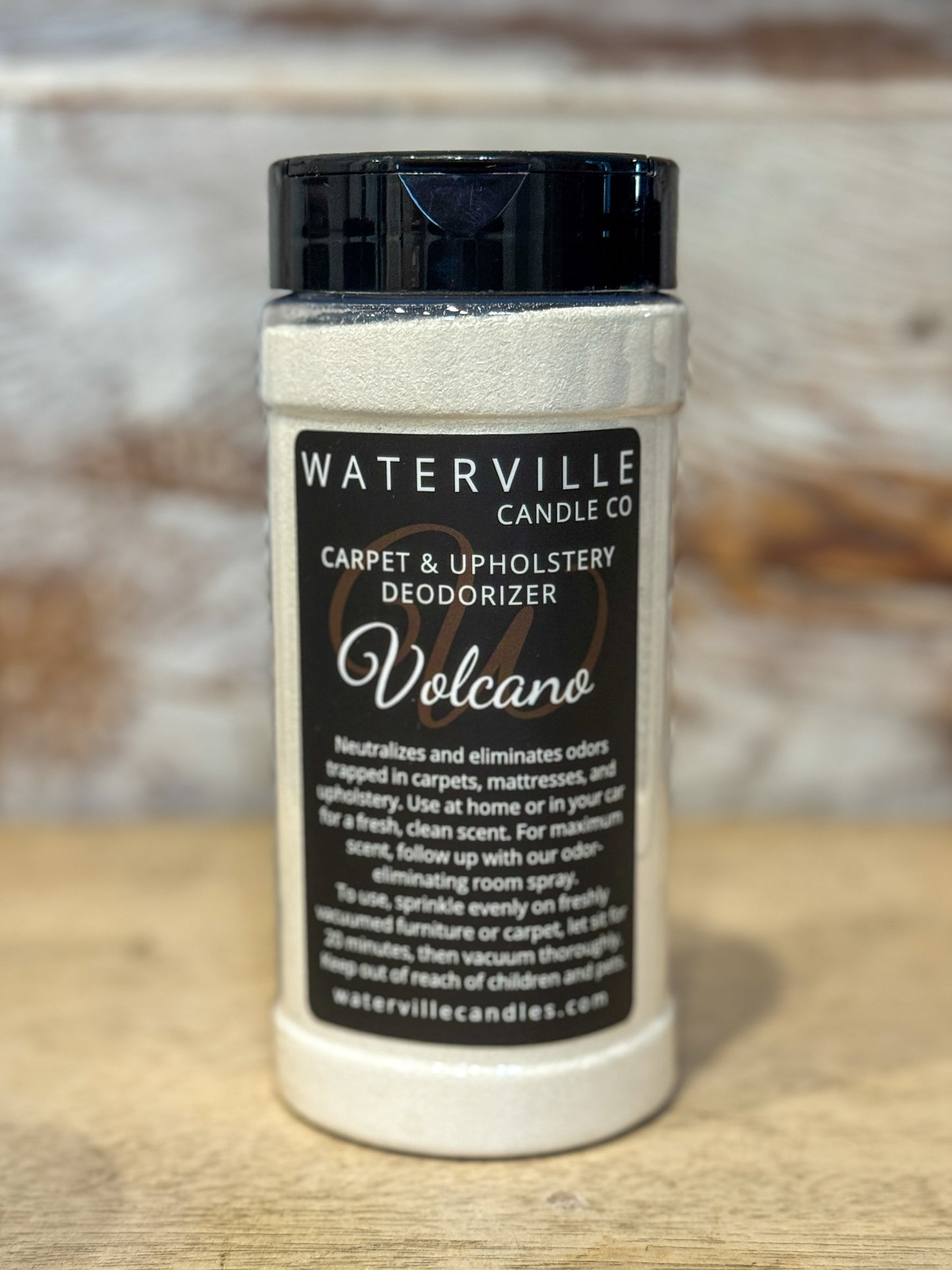 Jar of Waterville Candle Co. carpet and upholstery deodorizer labeled 'Volcano' on a wooden surface.