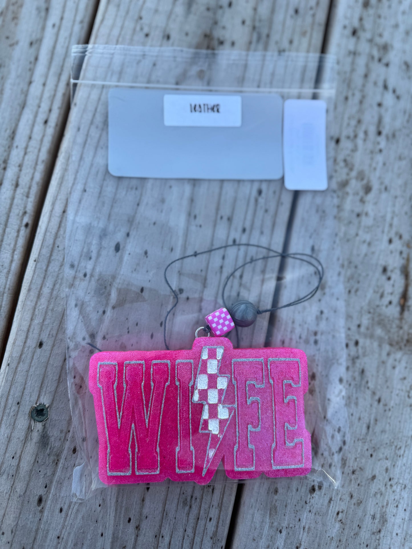 Pink 'WIFE' keychain with checkered design on a wooden surface