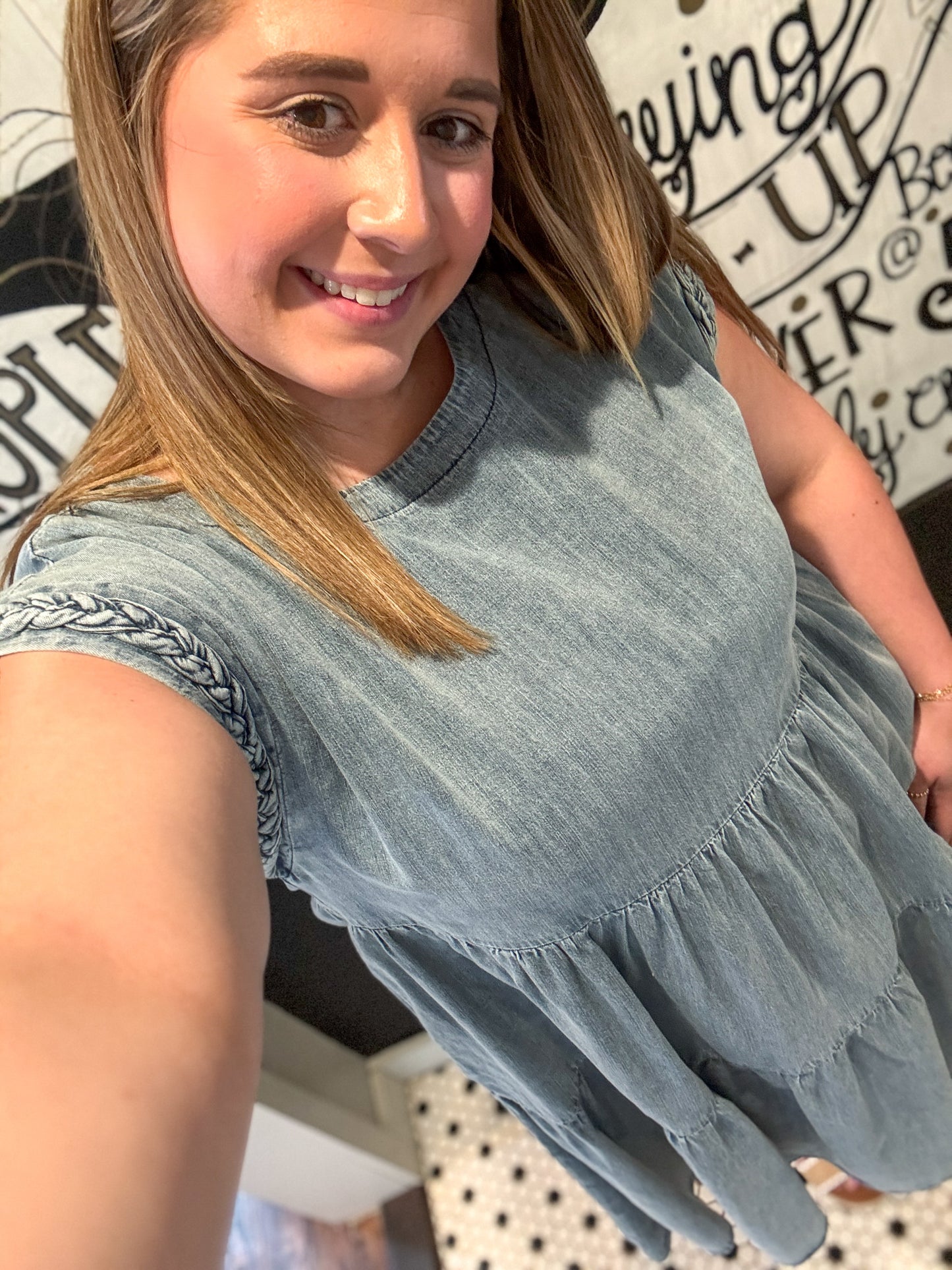 Woman wearing a light blue denim dress with a blurred background