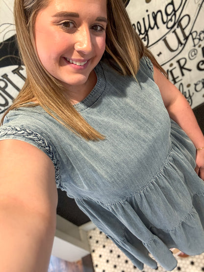 Woman wearing a light blue denim dress with a blurred background