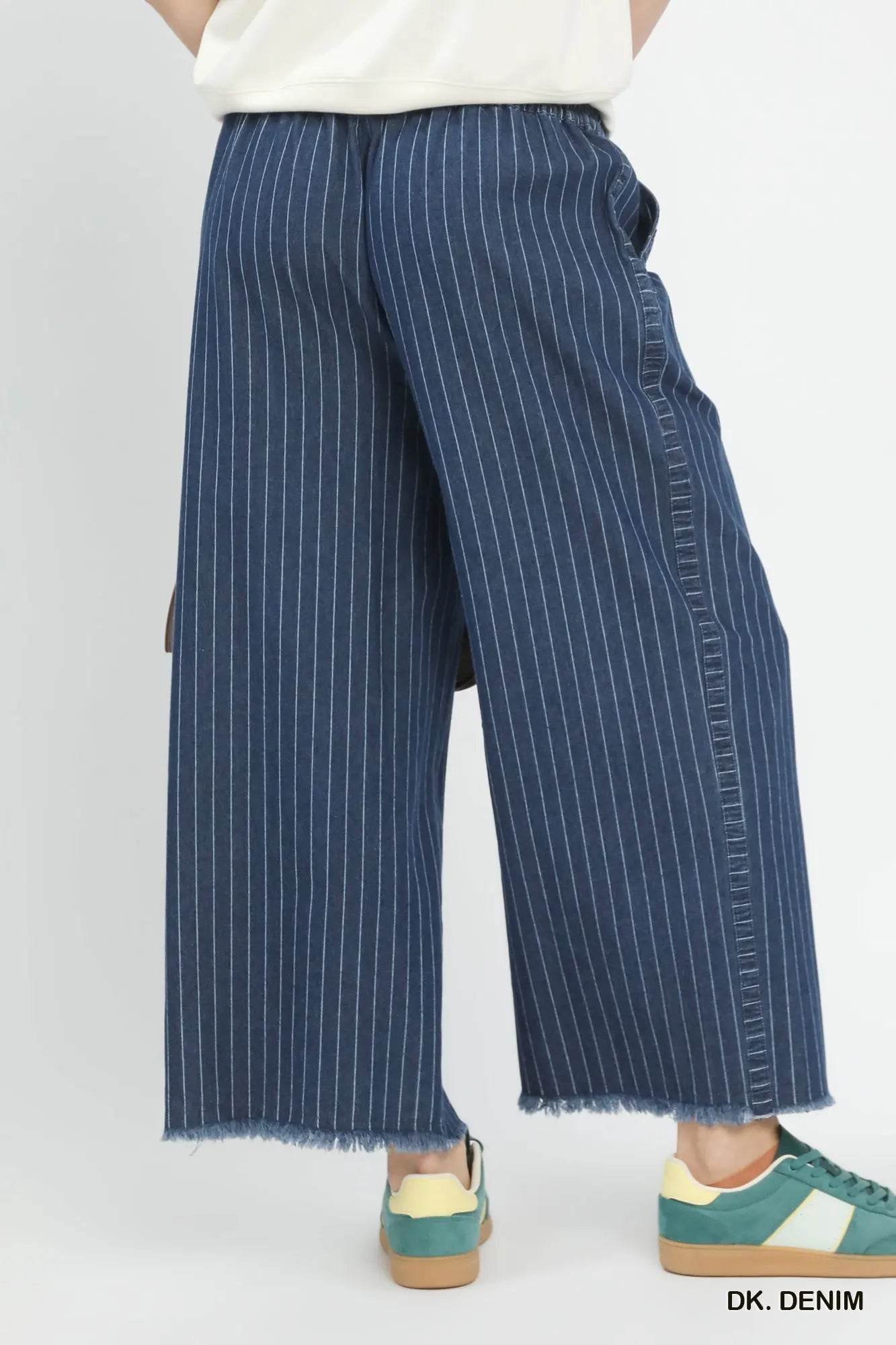 Blue pinstripe pants worn by a person on a white background