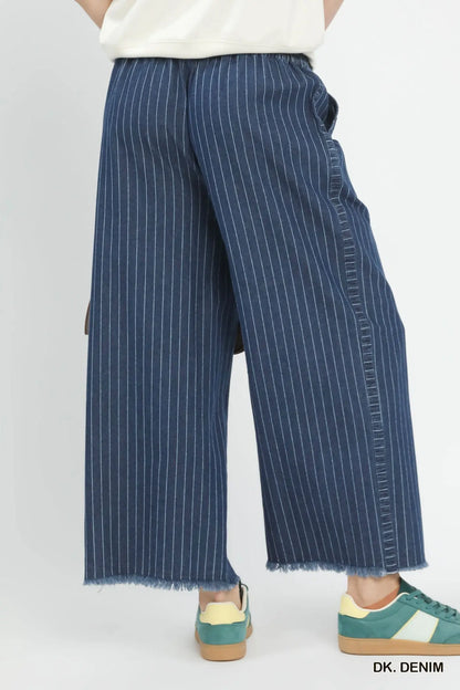 Blue pinstripe pants worn by a person on a white background